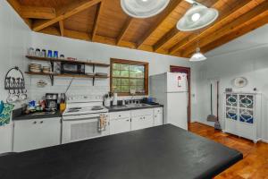 a kitchen with white appliances and a black counter top at Mountain Treehouse - Magpie Nest in Mentone
