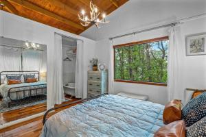 a bedroom with a bed and a window at Mountain Treehouse - Magpie Nest in Mentone +11 photos