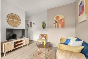 a living room with a couch and a tv at LA DUNE - Gare Matabiau - PARKING & WIFI in Toulouse