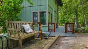 a wooden bench sitting in front of a house at Mountain Retreat Ruby's Roost Home & Loft in Mentone