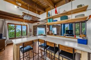 a kitchen with a bar with stools at Mountain Retreat Ruby's Roost Home & Loft in Mentone +134 photos