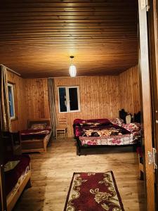 a bedroom with two beds in a wooden cabin at Bata GuesThouse in Adishi