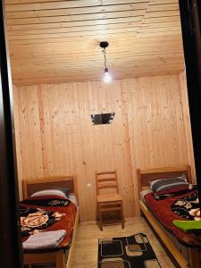 a room with two beds and a chair in it at Bata GuesThouse in Adishi