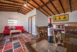 a living room with a red couch and a bottle of wine at Hotel Zocalo Campestre in Guatapé