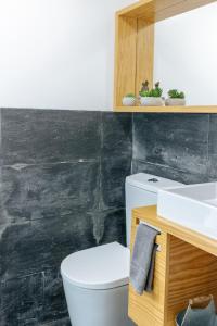 un bagno con un water bianco e un lavandino di Ria de Aveiro Villa by Mycelia a Ovar Altre 69 foto