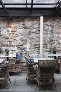 an outdoor table and chairs and a stone wall at Villa Gutebagge Hotell in Visby