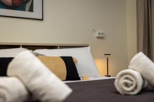 Un dormitorio con una cama con sábanas y almohadas blancas. en Nobia 3, en Atenas
