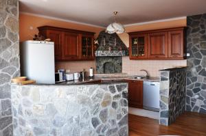 una cocina con armarios de madera y una pared de piedra. en Apartments Ananina en Portorož