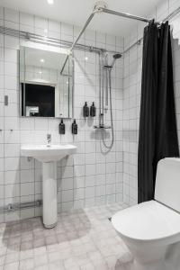 a bathroom with a sink and a shower and a toilet at Villa Gutebagge Hotell in Visby +36 photos