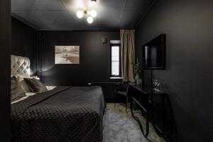 a black bedroom with a bed and a window at Villa Gutebagge Hotell in Visby