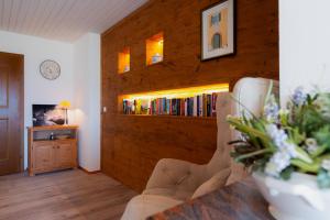 a living room with a book shelf with books at Pension Waldklause in Schönau am Königssee