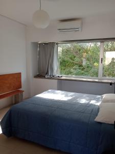 a bedroom with a blue bed and a window at Casa en Zona Parque San Carlos in Concordia