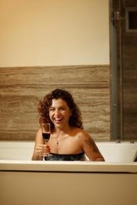 a woman sitting in a bath tub holding a glass of wine at Hotel El Condor in Paracas +28 photos