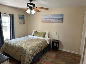 Un dormitorio con una cama y un ventilador de techo. en Hart 20 min to Epic Universe!, en Orlando