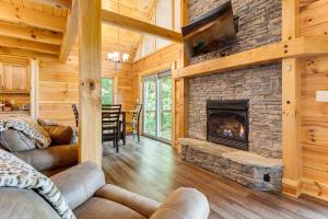 a living room with a fireplace in a log cabin at Waynesville Romantic Hideaway with Private Hot Tub in Waynesville