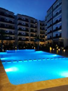 a large swimming pool in front of a building at night at Elegant & Cozy Beach Apartment in Mohammedia