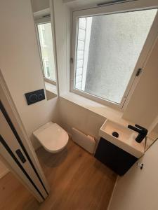 a small bathroom with a toilet and a window at Sentral leilighet i Bergen in Bergen +6 photos