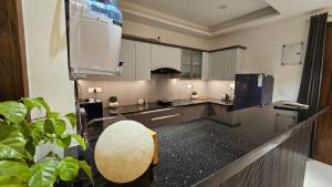a large kitchen with a large black counter top at Aalaya By Karamya Homes in Rishīkesh