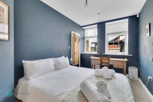 a blue bedroom with a large bed and a desk at Bantham Mews by Pureserviced 1 bedroom luxury mews in Plymouth