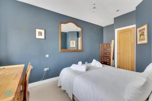 a blue bedroom with a bed and a mirror at Bantham Mews by Pureserviced 1 bedroom luxury mews in Plymouth +31 photos