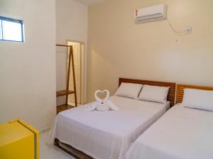 a room with two beds with a stuffed animal on it at Suítes Pe na Areia in Jericoacoara