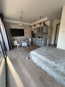 a large bedroom with a bed and a kitchen at Cozy Apartment in Vilnius Paupys in Vilnius