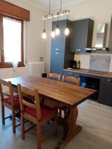 Una cocina con una mesa de comedor y sillas de madera. en Casa Val Grande, en Pianello Del Lario