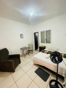Un dormitorio con una cama, un sofá y una mesa. en Suíte Privativa Central próximo a unip, São Leopoldo Mandic,Shopping iguatemi, en Campinas
