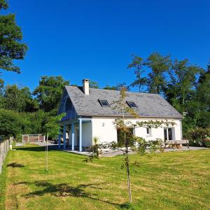 ein weißes Haus mit einem Baum im Hof in der Unterkunft La maison au bout du chemin in Poey-dʼOloron
