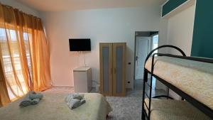 a bedroom with two beds and a flat screen tv at rosy house in Scalea +6 photos