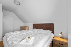a bedroom with a white bed with a wooden headboard at Lipno Lakeside 45 in Frymburk +40 photos