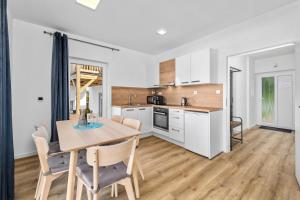 a kitchen and dining room with a table and chairs at Lipno Lakeside 45 in Frymburk