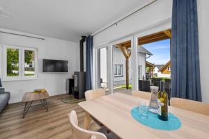 a dining room with a table with a bottle of wine at Lipno Lakeside 45 in Frymburk