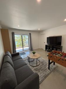 a living room with a couch and a table at Chalet Cottage Le Bellevarde Hot tub Lake view in Saint-Aimé-Du-Lac-des-Îles