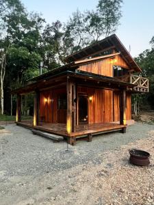 a large wooden house on a gravel lot at Cabana Maktub in Nova Veneza