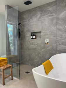 a bathroom with a tub and a glass shower at Chalet Cottage Le Bellevarde Hot tub Lake view in Saint-Aimé-Du-Lac-des-Îles +31 photos