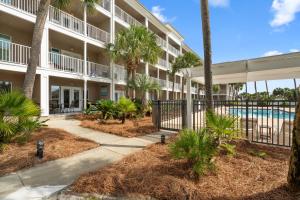 ein Apartmentgebäude mit einem Pool und Palmen in der Unterkunft Grand Caribbean East Poolside Palms in Pensacola