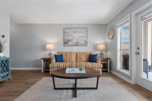 ein Wohnzimmer mit Sofa und Tisch in der Unterkunft Grand Caribbean East Poolside Palms in Pensacola