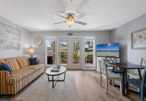 ein Wohnzimmer mit Sofa und Tisch in der Unterkunft Grand Caribbean East Poolside Palms in Pensacola + 40 Fotos