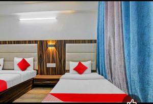 Un dormitorio con dos camas con almohadas rojas. en Hotel Alfa Manali, en Manali
