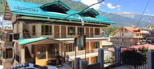 Un edificio con un techo azul encima. en Hotel Alfa Manali, en Manali