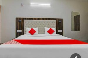 Un dormitorio con una cama grande con almohadas rojas. en Hotel Alfa Manali, en Manali