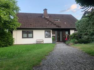 una casa blanca con un banco delante en Auszeitwohnung, en Lage