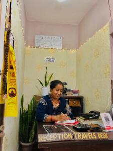 Una mujer sentada en un escritorio en una habitación. en Hotel Aarjan And Restaurant, en Pokhara