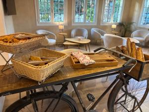 a table with baskets of bread and a bike at Hôtel Beau Site - Cap d'Antibes in Antibes