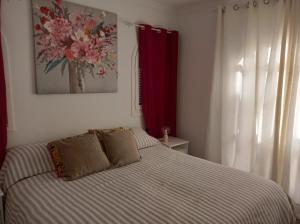 a bedroom with a bed and a painting on the wall at Casa Chloe Jandía in Morro del Jable