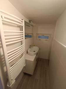 een witte badkamer met een wastafel en een toilet bij La petite maison Soleil in Biella +4 foto's