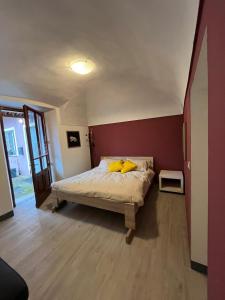 een slaapkamer met een bed met gele kussens erop bij La petite maison Soleil in Biella