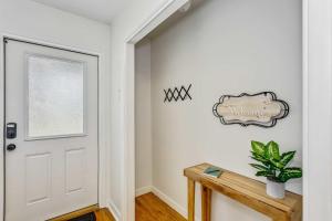 pasillo con puerta blanca y mesa de madera en Near Downtown Beach House&Apt - Woodland Escape, en Pensacola