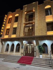 Un edificio con una alfombra roja delante. en Beksaroy, en Samarkand